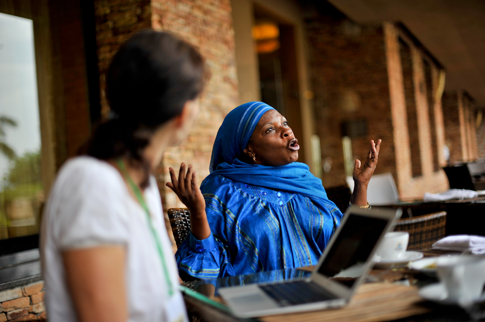 Lady sitting at table discussing something with a female colleague blurred in the foreground