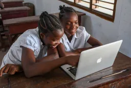 Two girls helping each other to learn a concept using a laptop